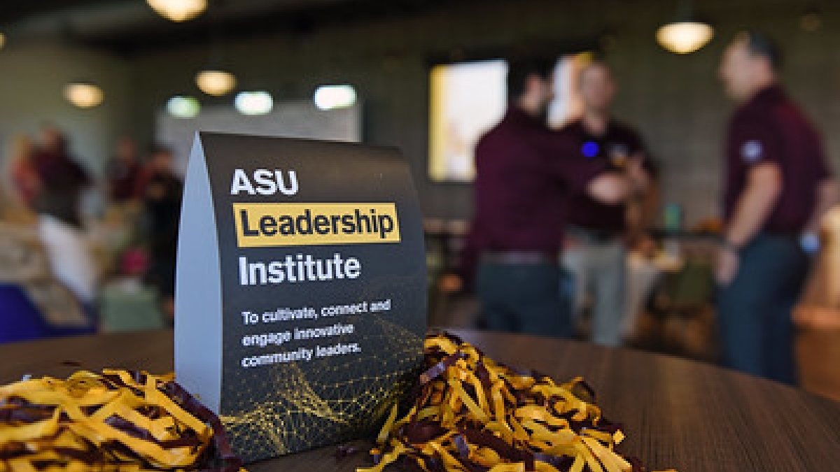 ASU Leadership Institute  sign on a table surrounded by pom-poms.