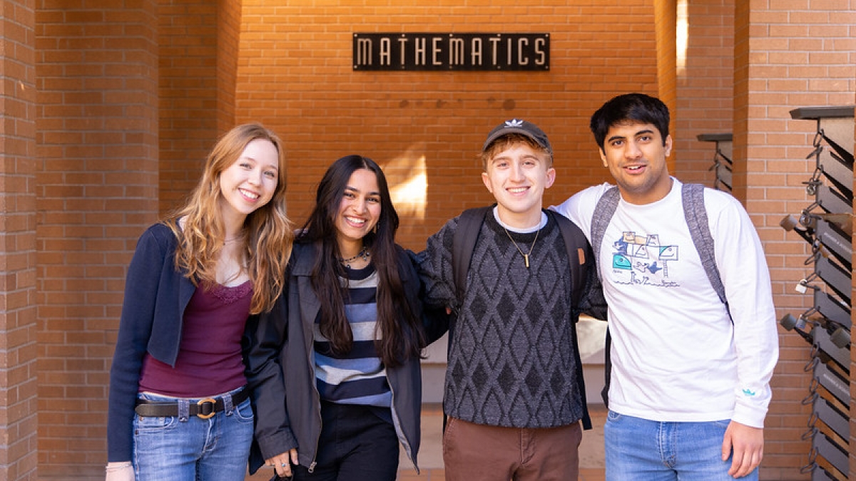 Students in the School of Mathematical and Statistical Sciences smile outside Wexler Hall.
