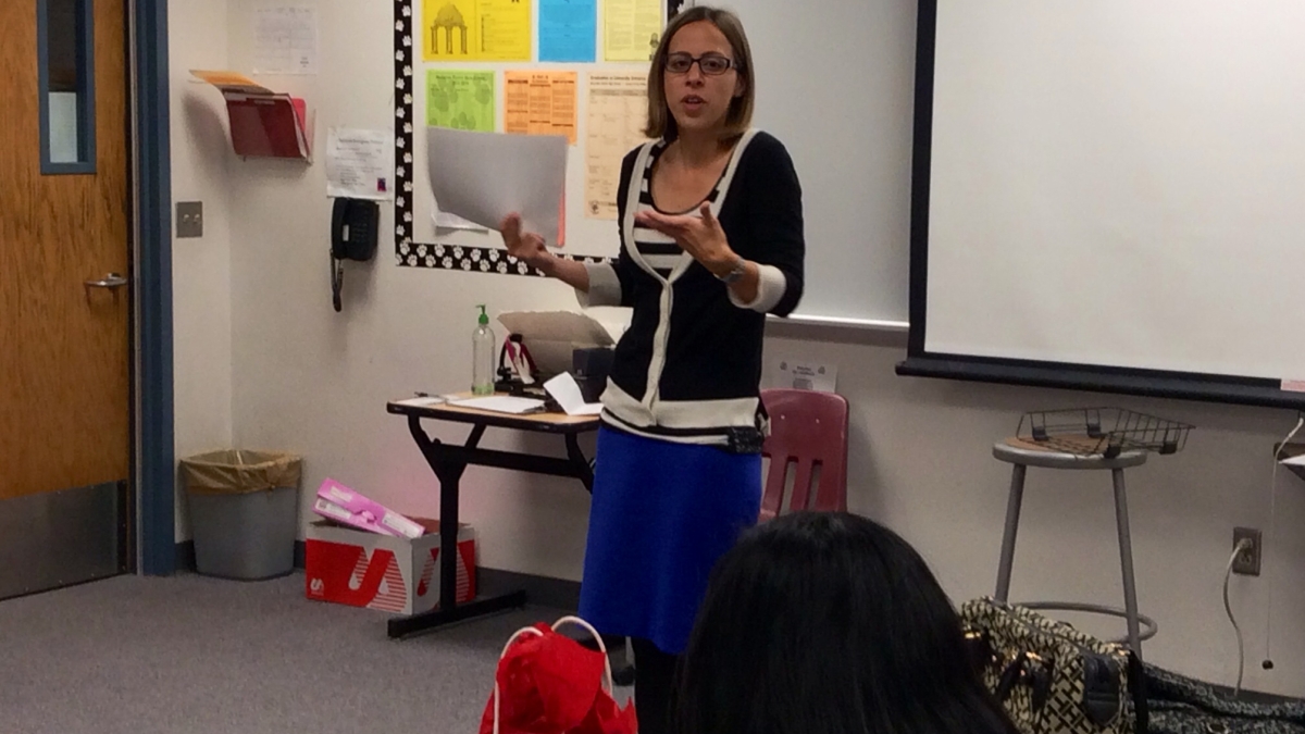 Adela Grando speaking at front of classroom