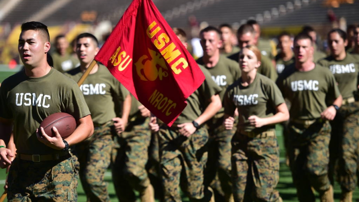 Members of the Marine ROTC run at the Salute to Service football game in 2014
