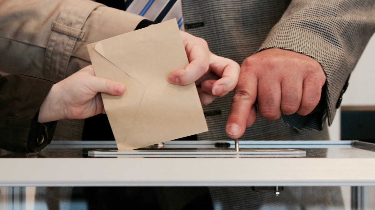 People placing ballots into box