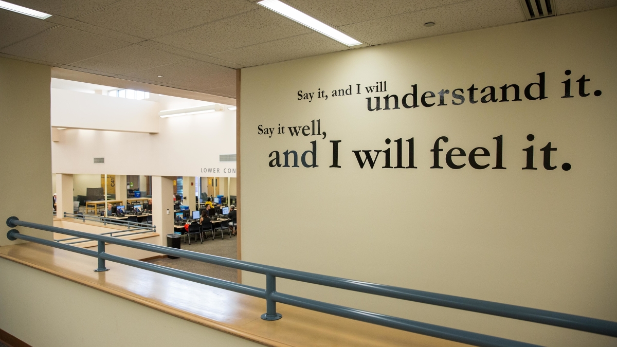 phrase displayed on a wall lin a library