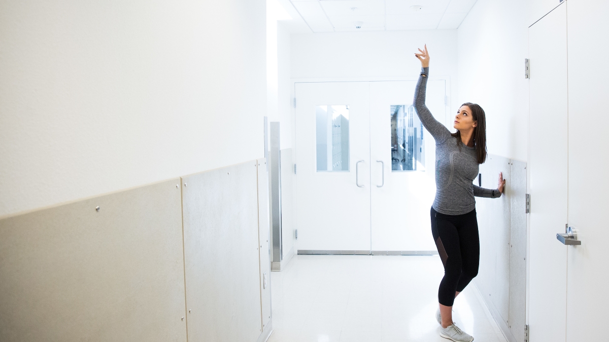 woman in dance pose in lab hallway