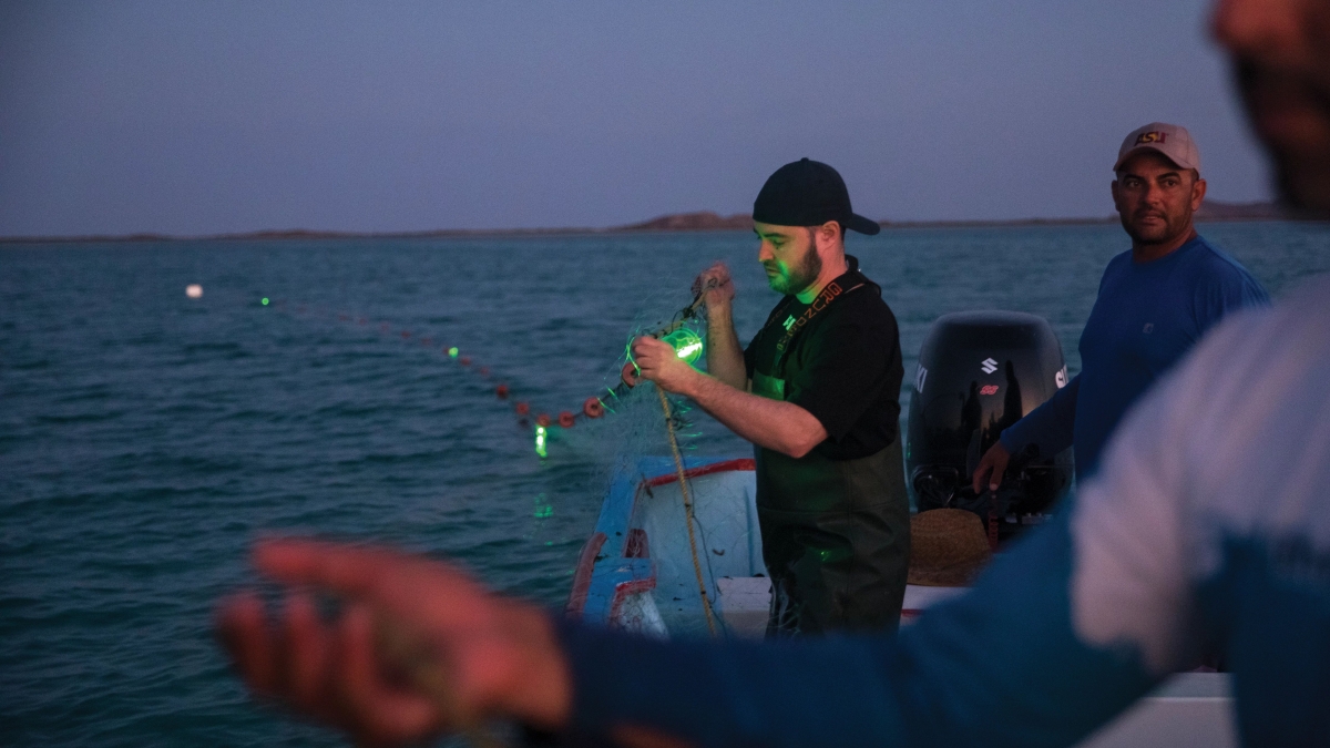 ASU marine biologist Jesse Senko using illuminated nets on a boat in the ocean.