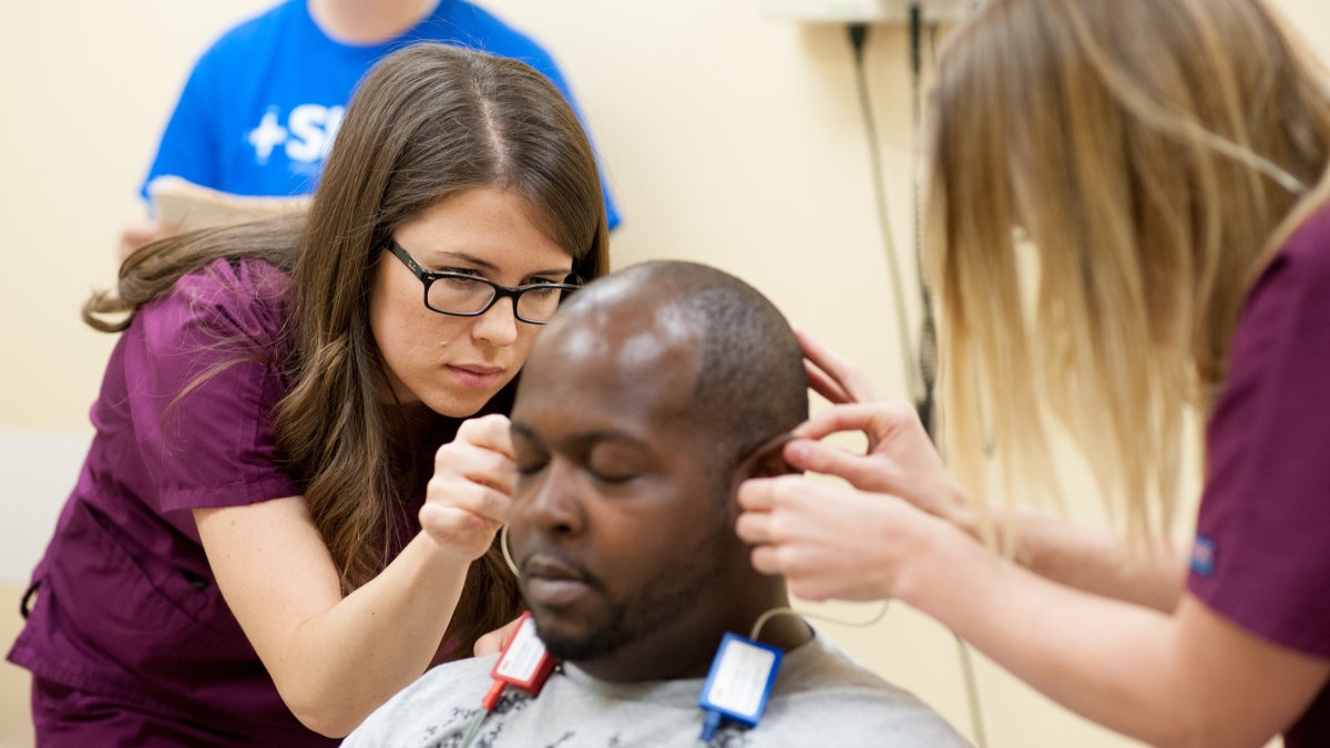 Medical personnel examine a man&#039;s hearing.