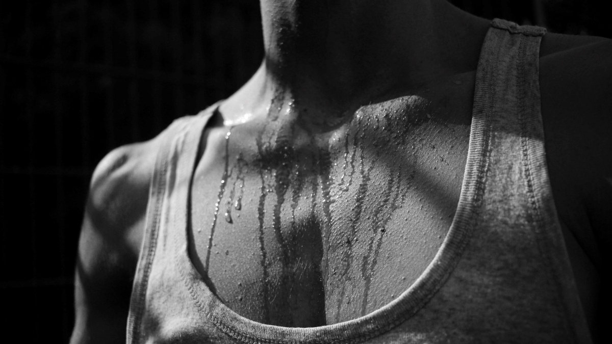 black and white close-up of person's chest with sweat on it