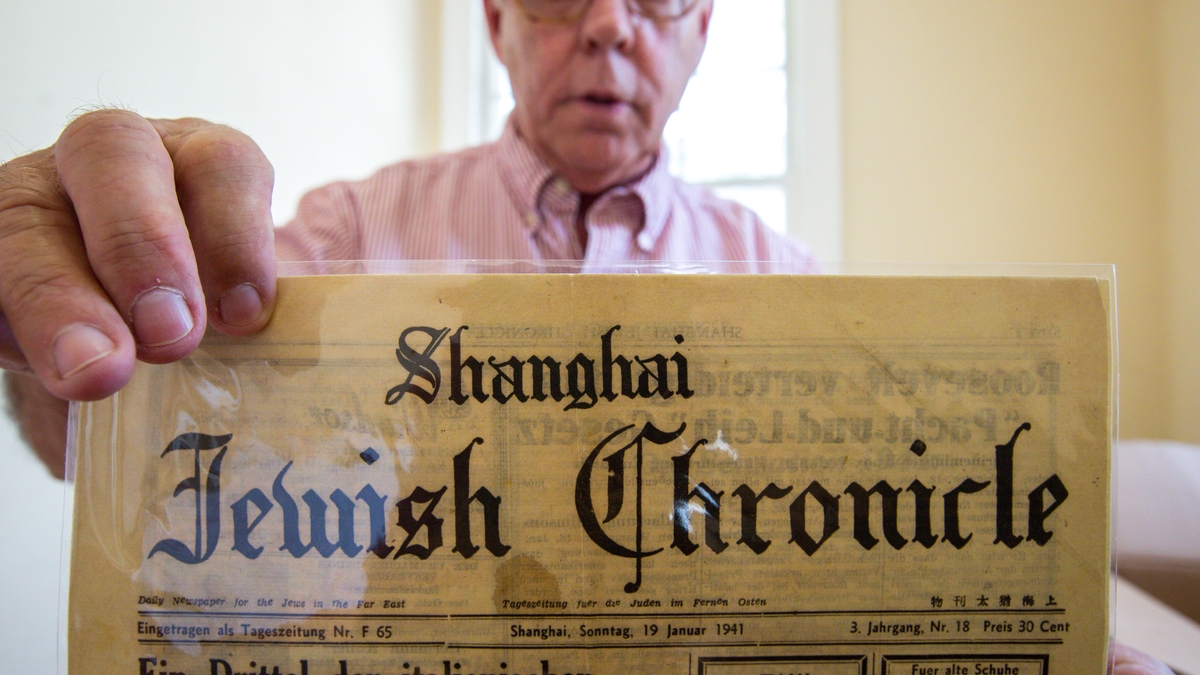Curator showing old newspaper