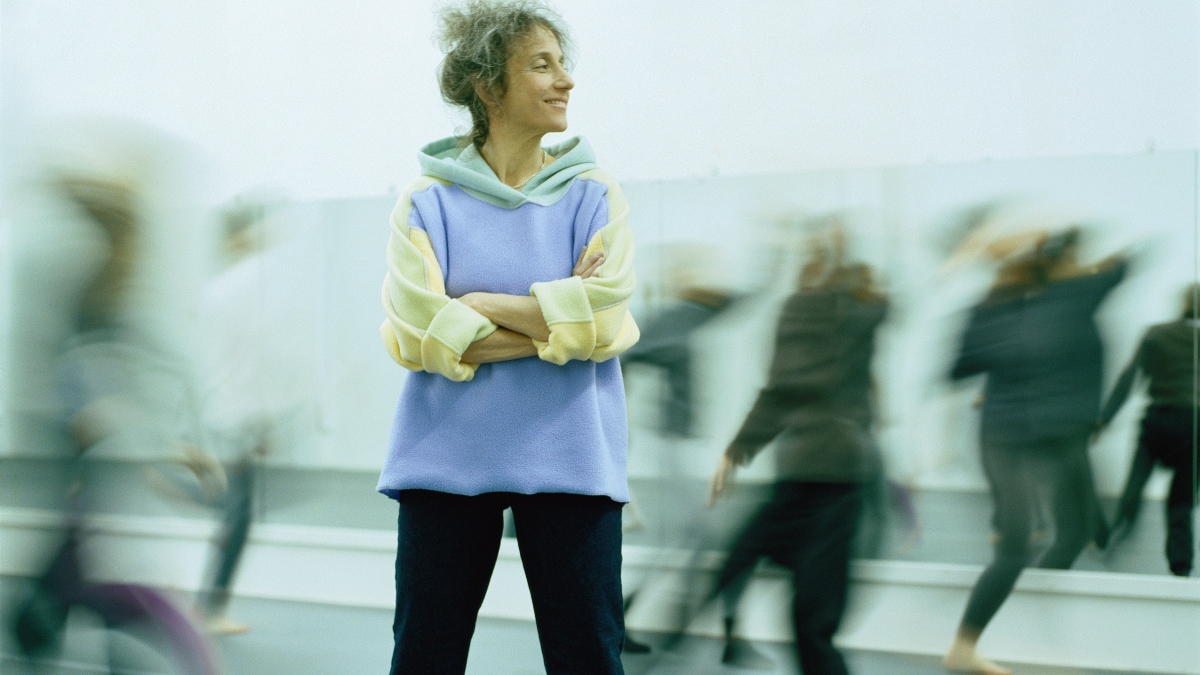 Woman standing among dancers.