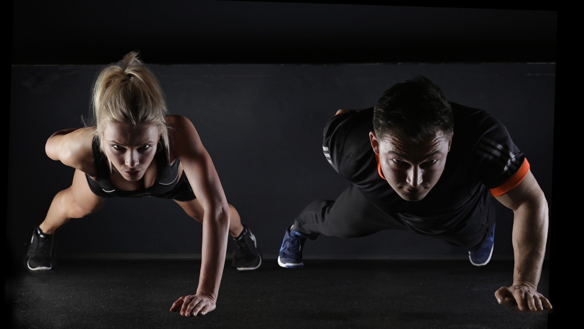 woman and man doing a one-armed push-up