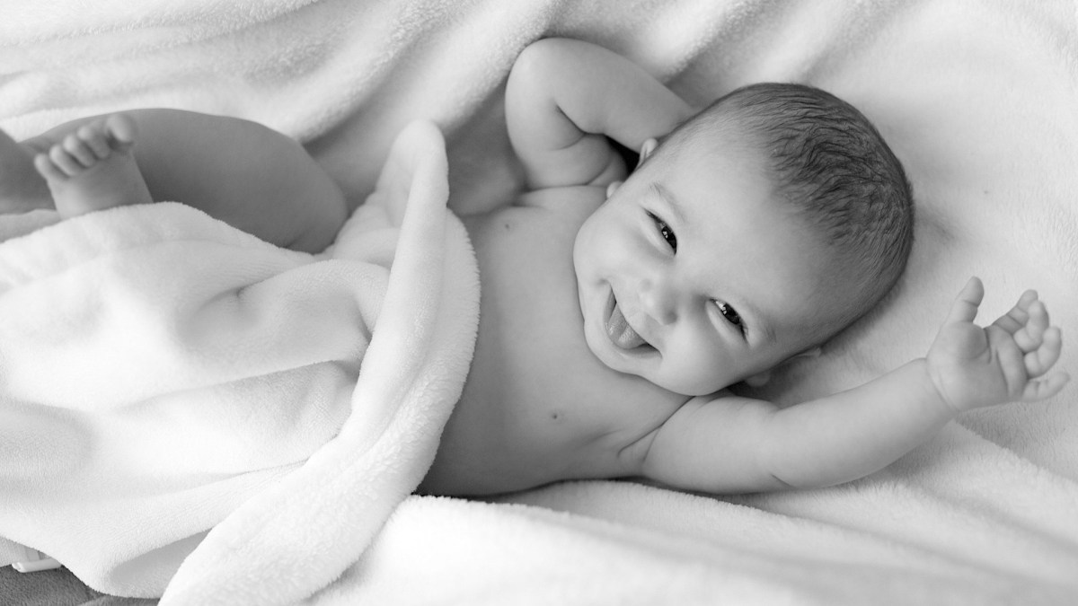 black and white photo of a baby smiling