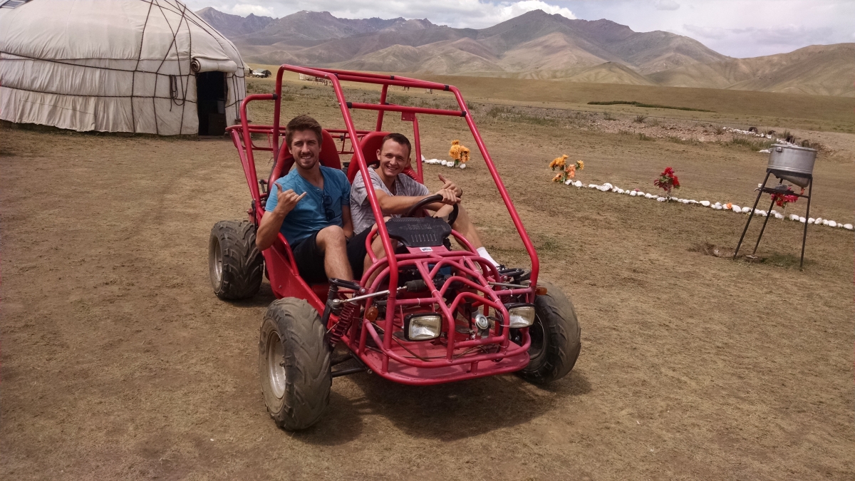 two men in a go-cart near a mountain range