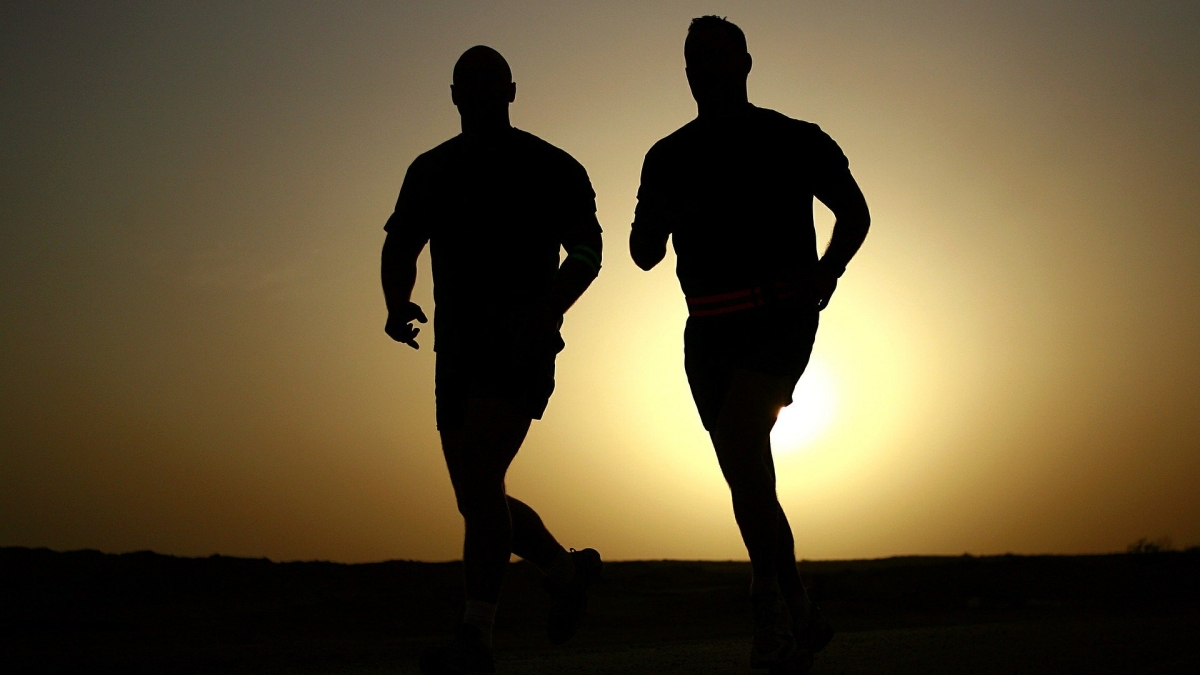 silhouettes of two people running