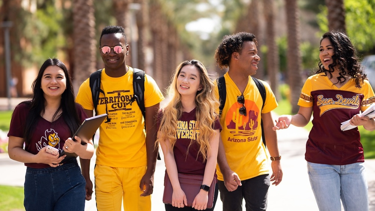 Arizona State University students smiling and walking in a group on campus