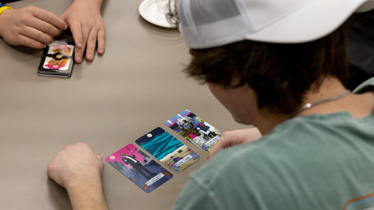 Student Owen Spieth looks at cards from the Humane Technology Tarot Deck
