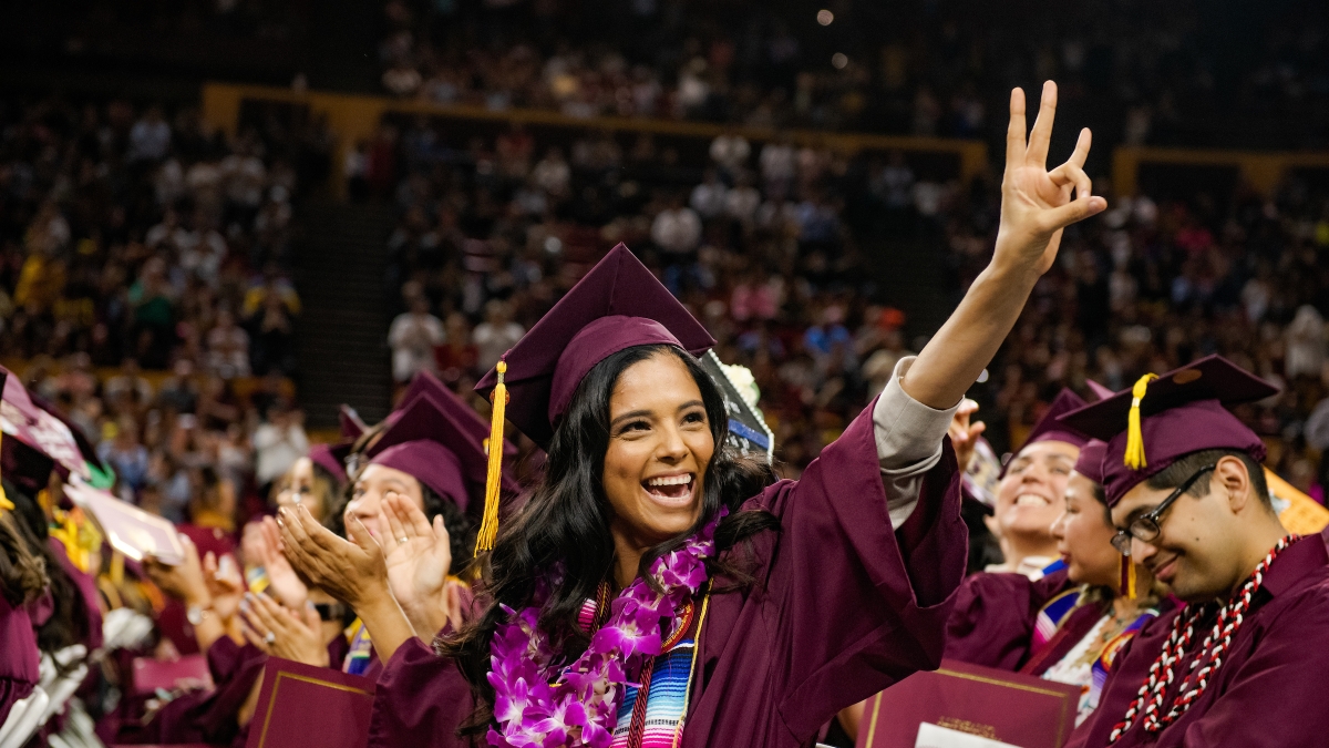 student at ASU Hispanic Convocation making a pitchfork with her hand