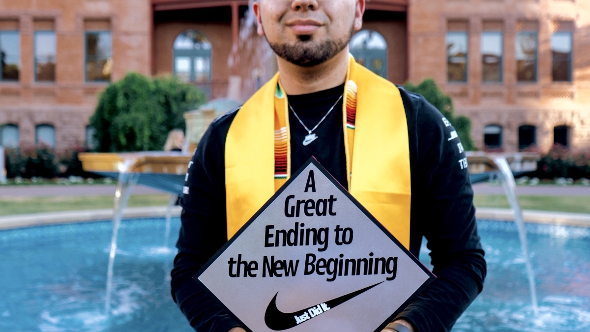 Joaquin Ramos poses at ASU's Old Main with his graduation cap and stole