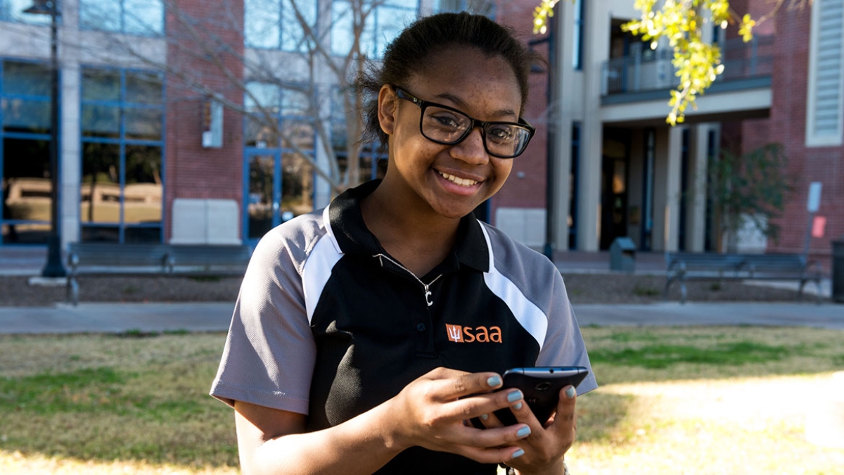 Female student holding Android device with ASU Learn to thrive app
