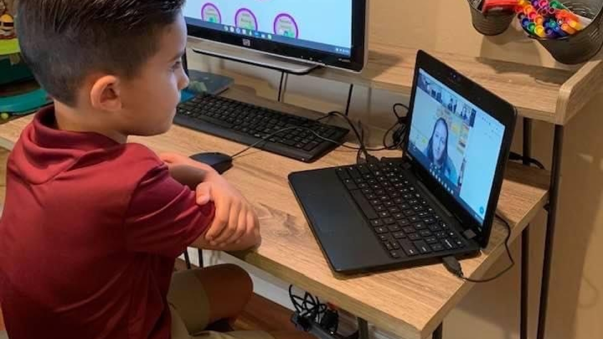 Child using computers to learn online at home