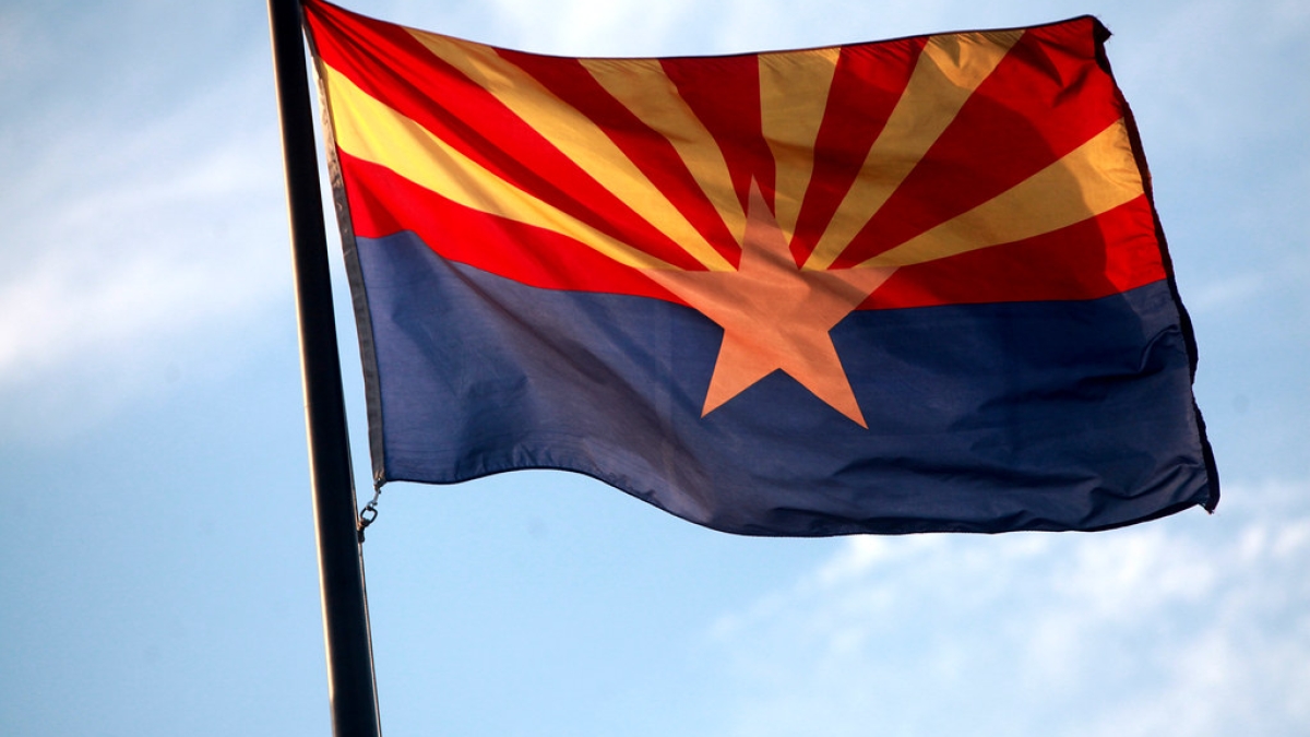 Arizona State flag with a blue sky in the background