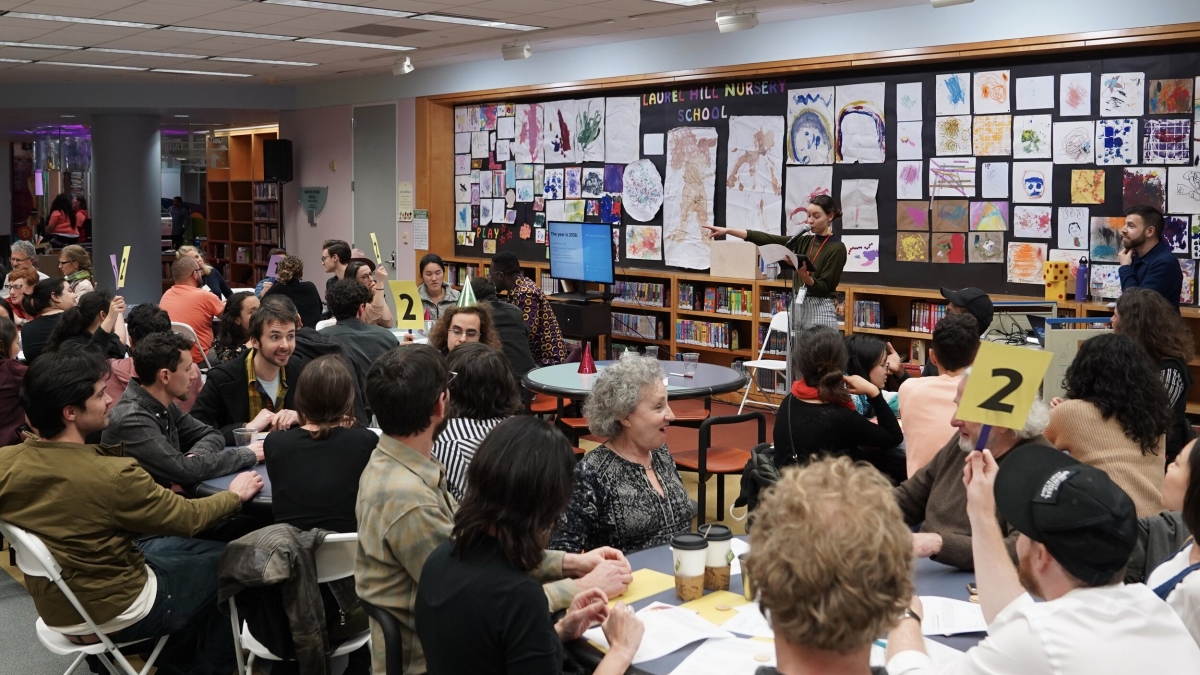 Groups of people at different tables participate in Future Perfect in February 2020 at the San Francisco Public Library as part of the San Francisco Night of Ideas Festival.