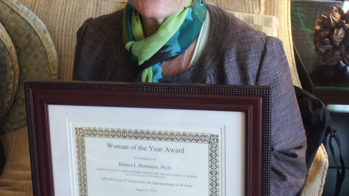 woman holding a framed certificate