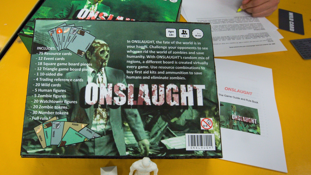 The pieces of a student-created zombie board game are displayed on a table.
