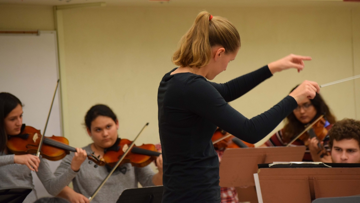 Melanie Brooks, graduate student in conducting, works with students from the ASU Concert Band and Phoenix Harmony House.