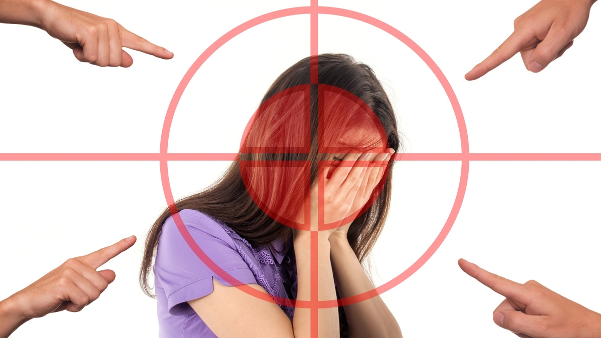 fingers pointing at a woman covering her face in shame