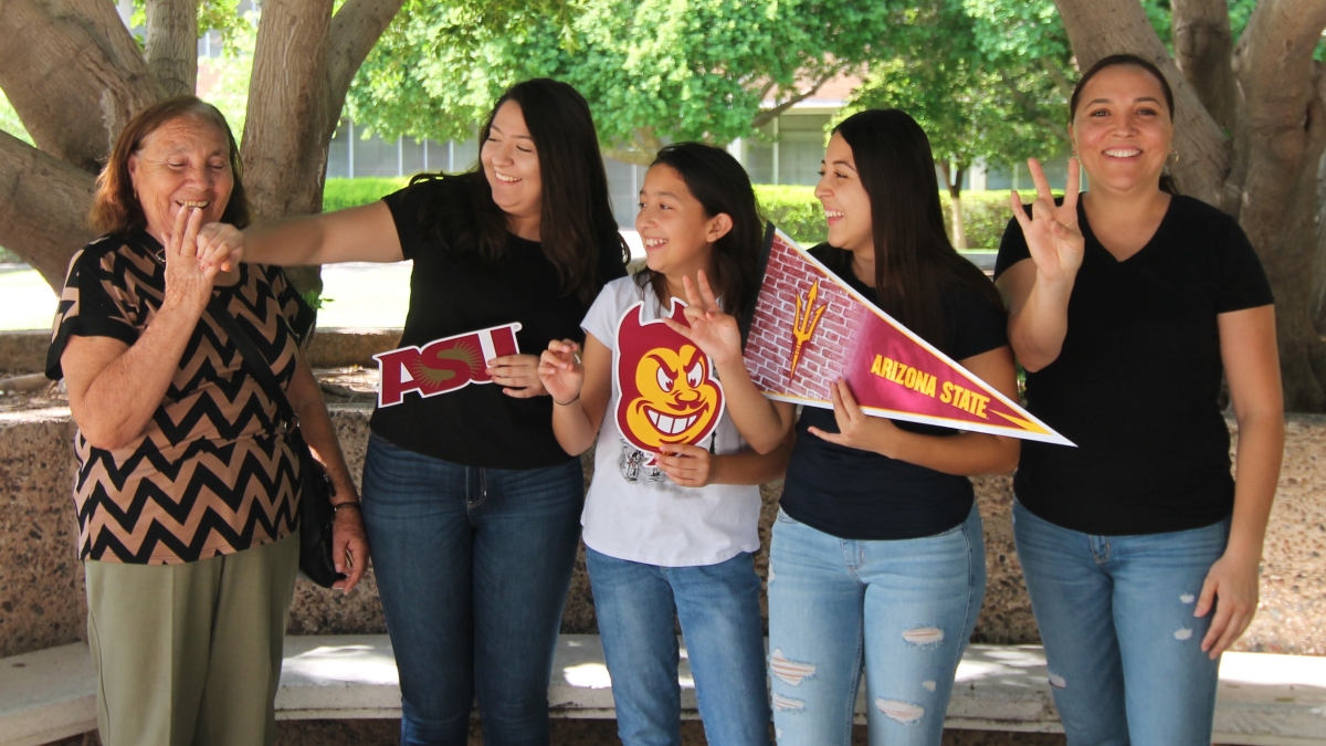 Family of a CAMP student posing for picture with ASU-themed signs.