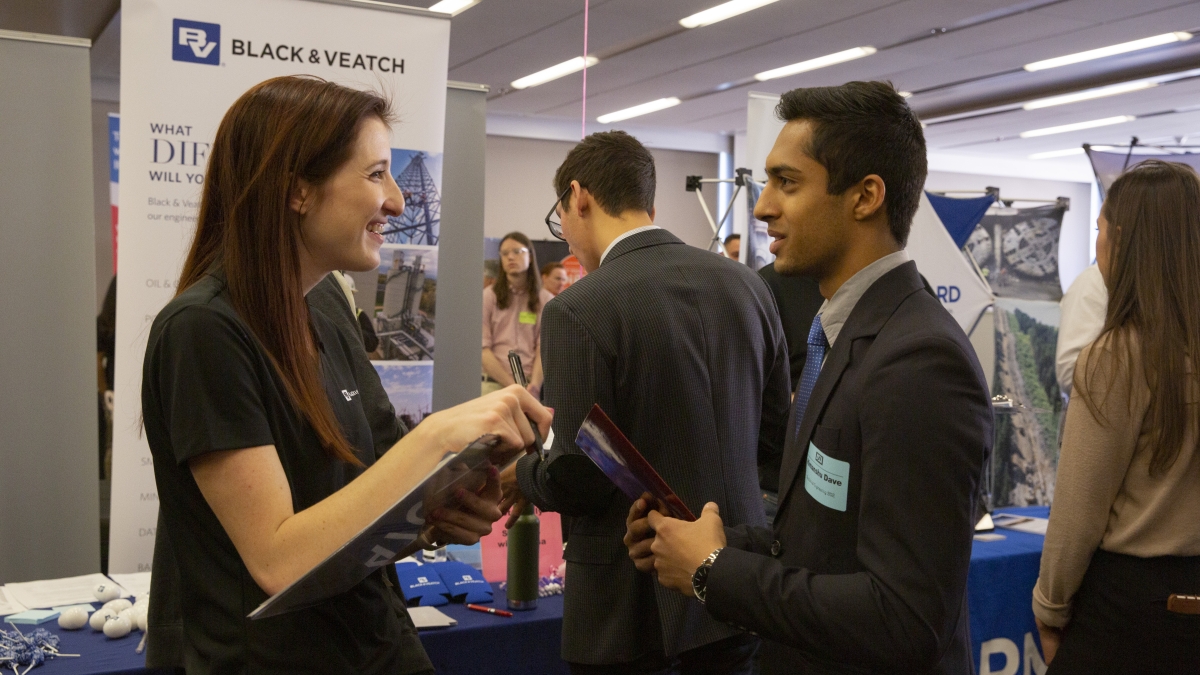 student talking to an employer at a career fair