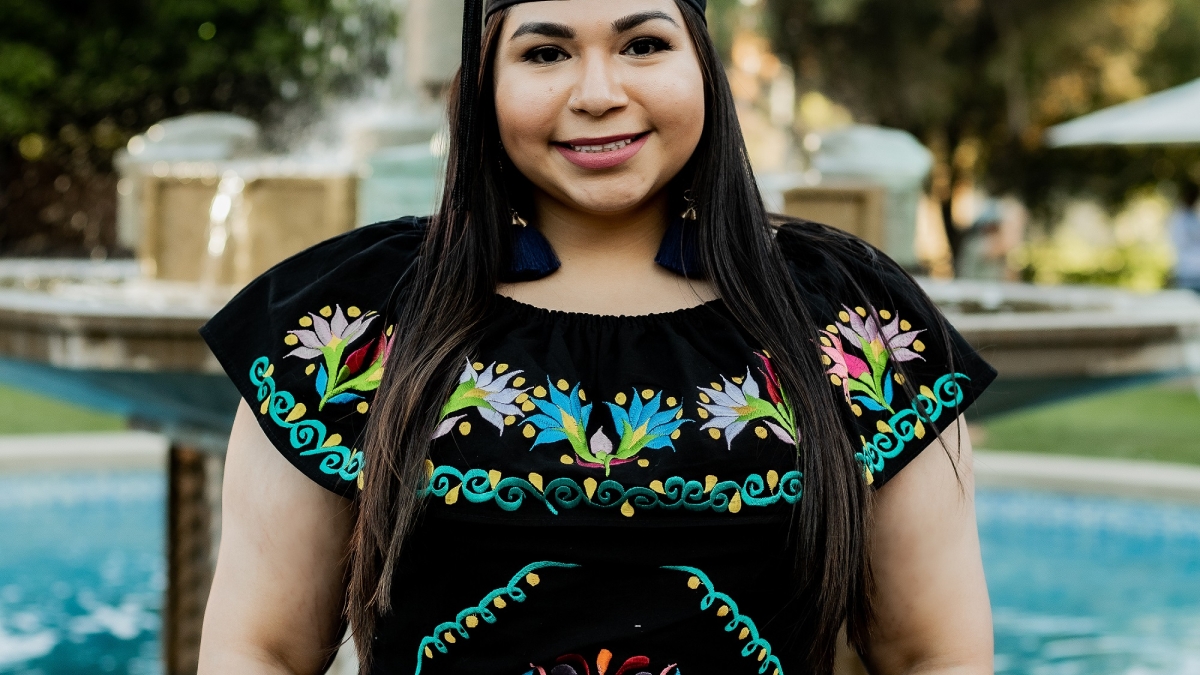 Carolina Tovar in her graduation cap in front of the Old Main fountain at ASU's Tempe campus