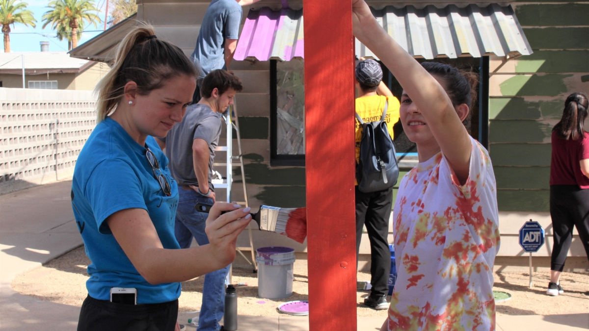 Two ASU students paint during a day of service