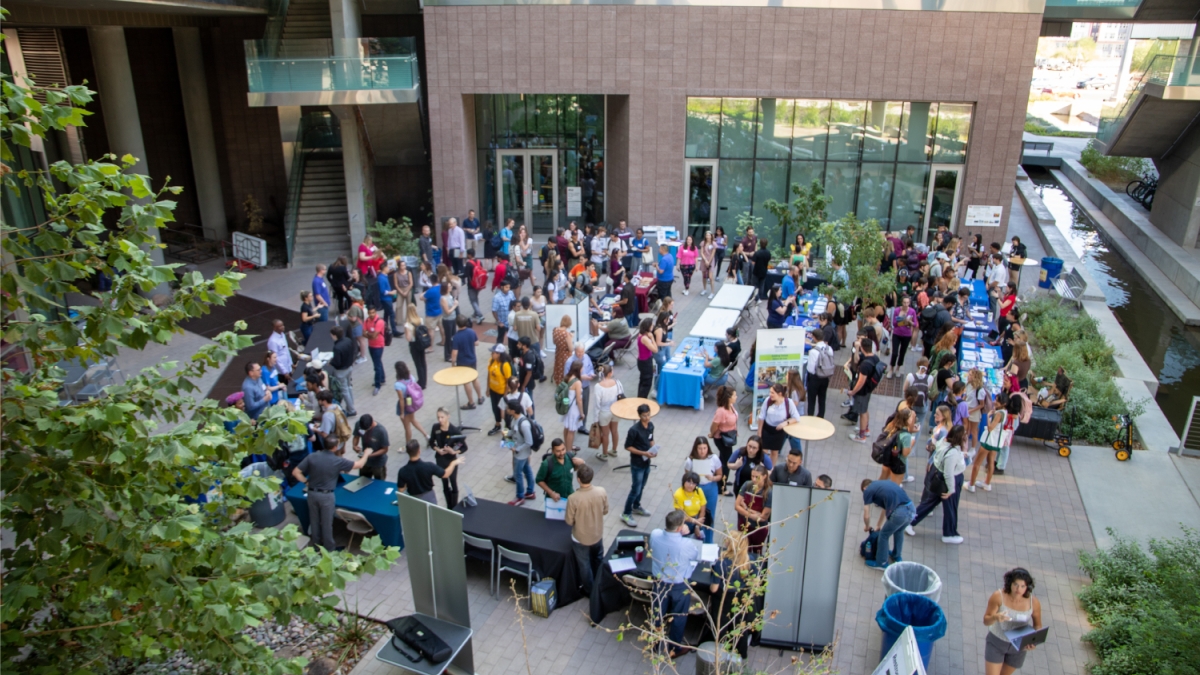 Large crowd of people seen from above while networking in a courtyard area.
