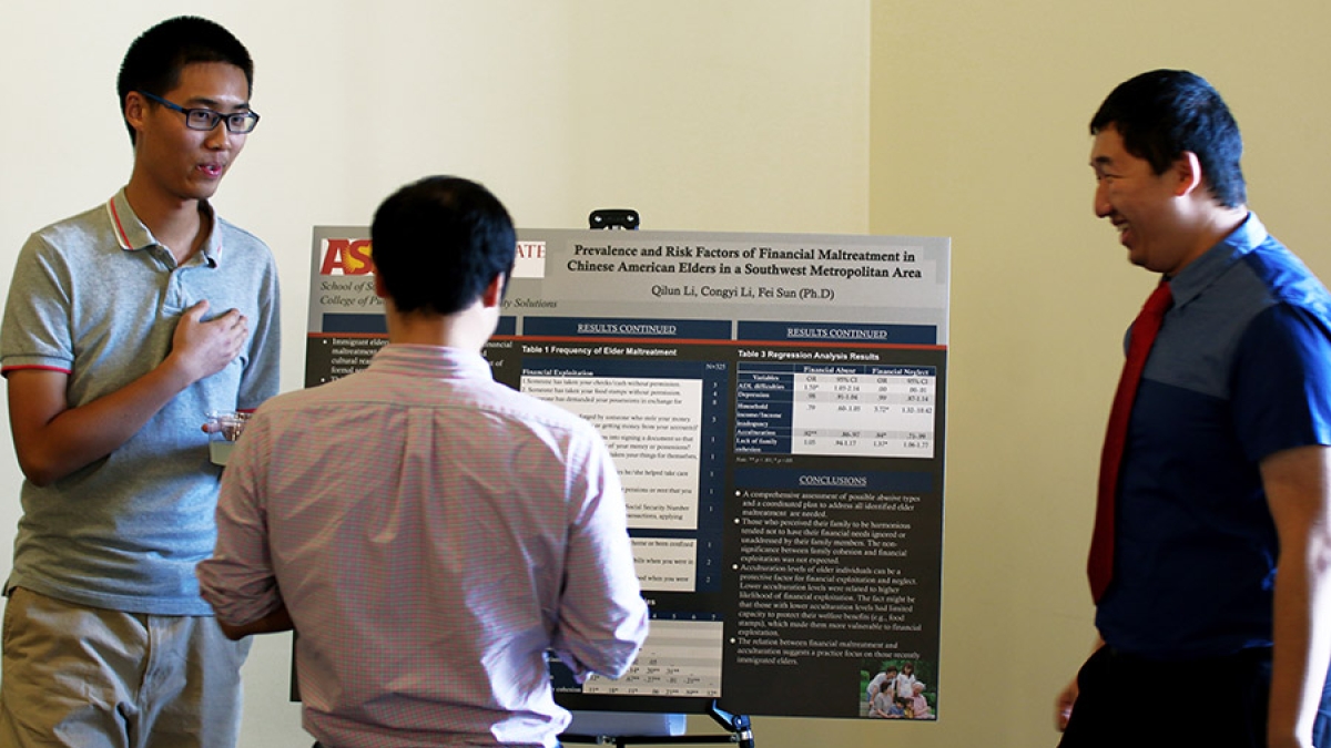 Congy Li and Qilun Li discuss their research results at an undergraduate research symposium sponsored by the College of Public Service and Community Solutions.