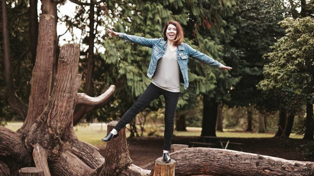 Courtney Baxter stands on a log