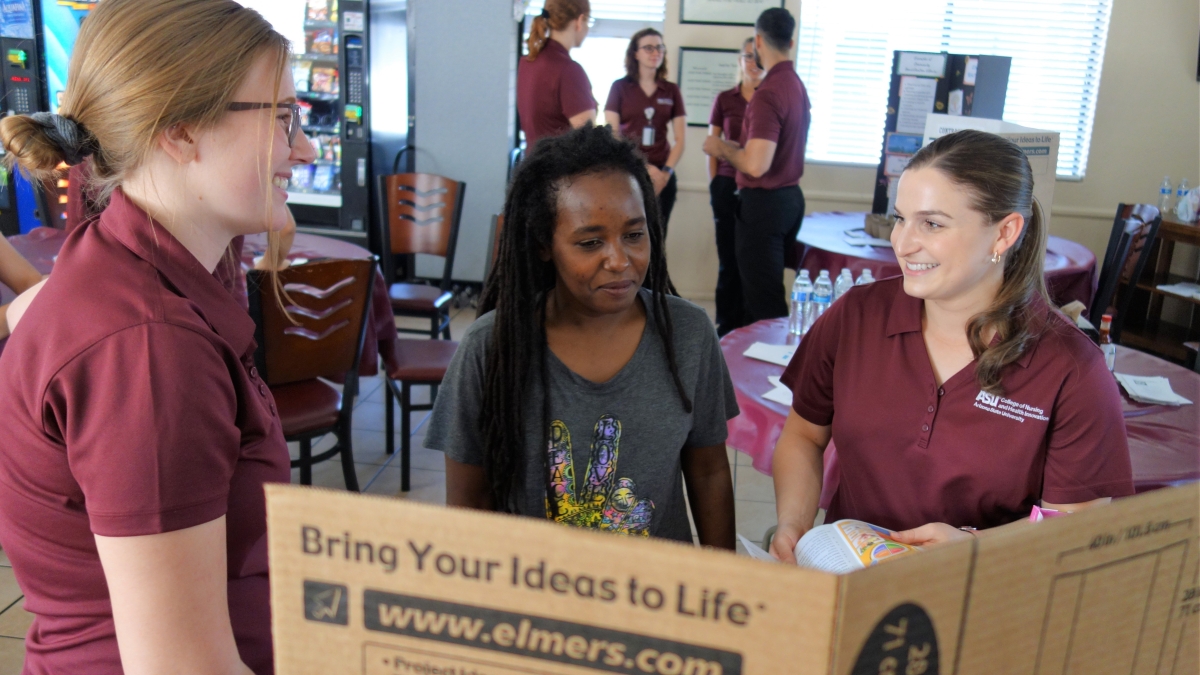 ASU nursing students talk with a Crossroads resident during a Health Fair