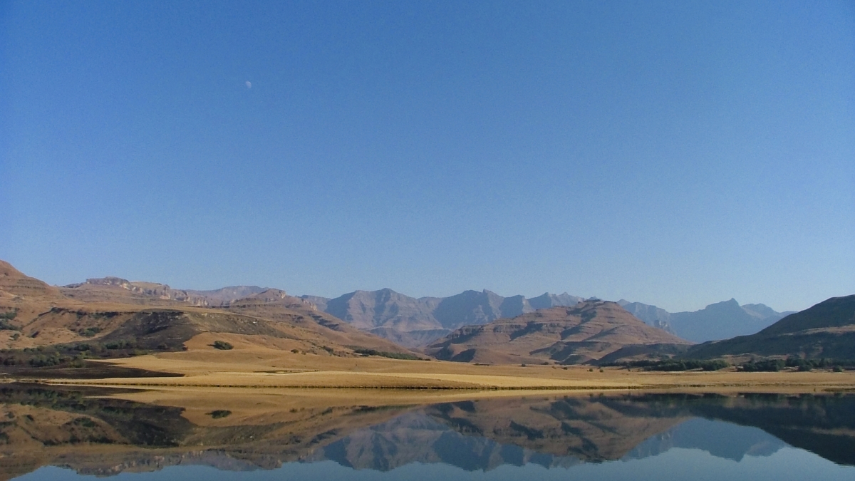 A desert lake with mountains reflected in the water.