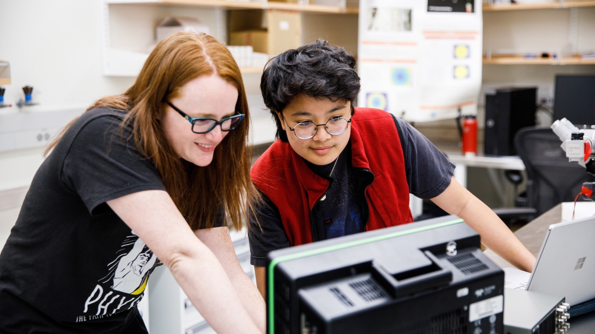 two students in a lab look at computer equipment