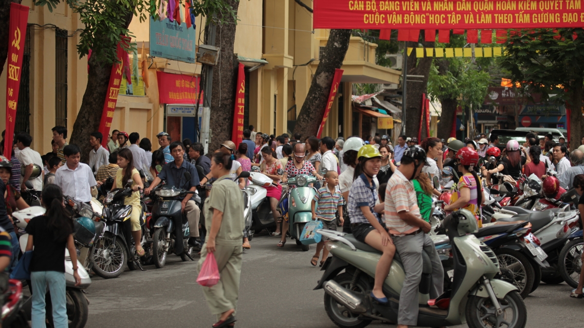 A busy street full of pedestrians and cyclists in Vietnam.