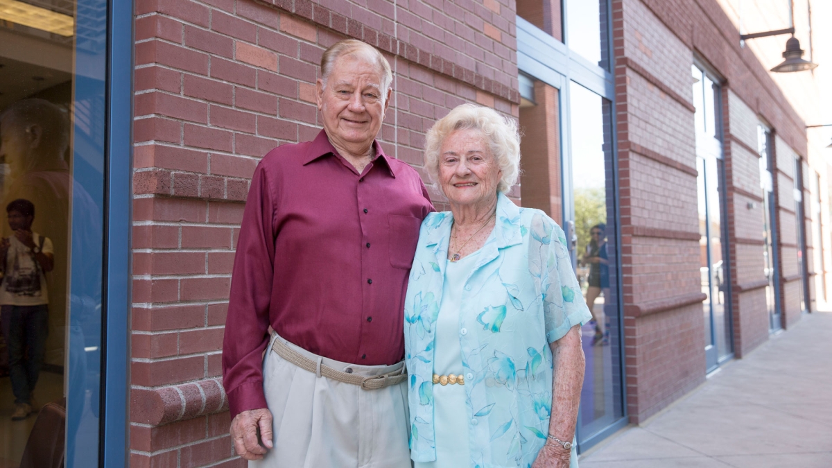 Jim and Marilyn Schmidlin standing outside a brick building.