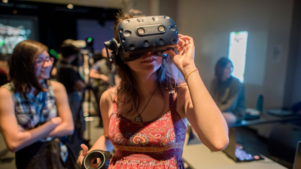 A woman uses a virtual reality headset at a digital showcase event.