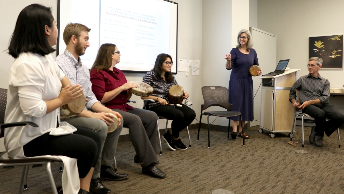 Participants in a drum workshop at a cancer center