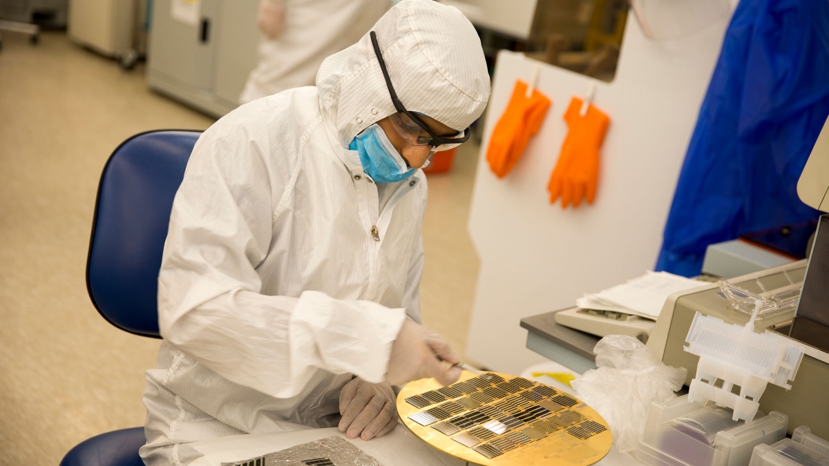 A researcher works with semiconductor materials in a lab.
