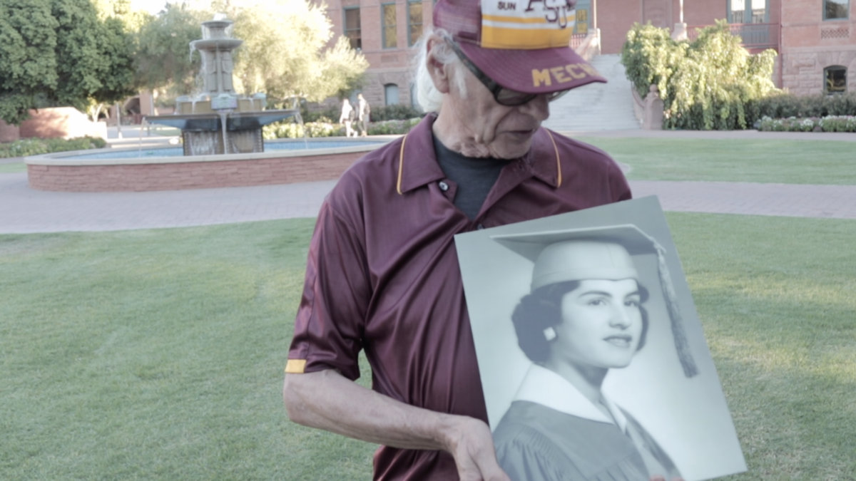 Edward Delci holds a portrait of his late wife, Virginia Pesqueira, in front of Old Main at ASU's Tempe campus