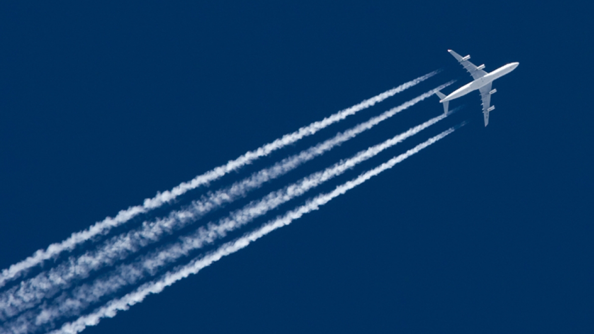 A plane flying with contrails.
