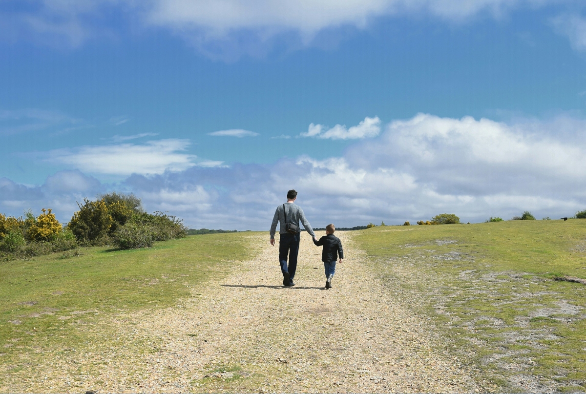 man and child walking along a path