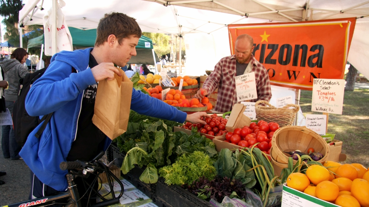 student picking out produce at food stand