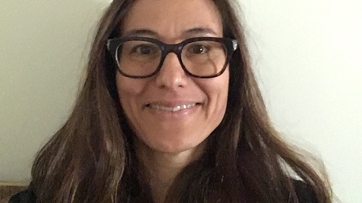 portrait of Camilla Fojas, director of ASU’s School of Social Transformation. Fojas has long dark hair, is smiling and wearing glasses