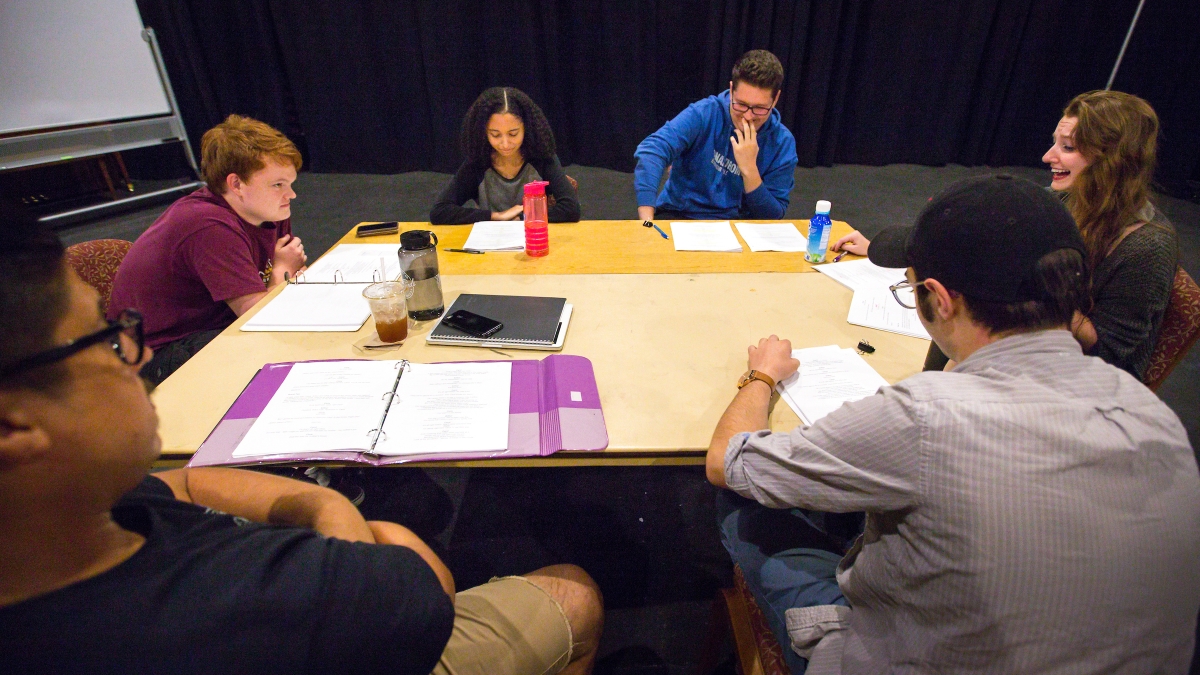 Student actors do a read-through around a table.