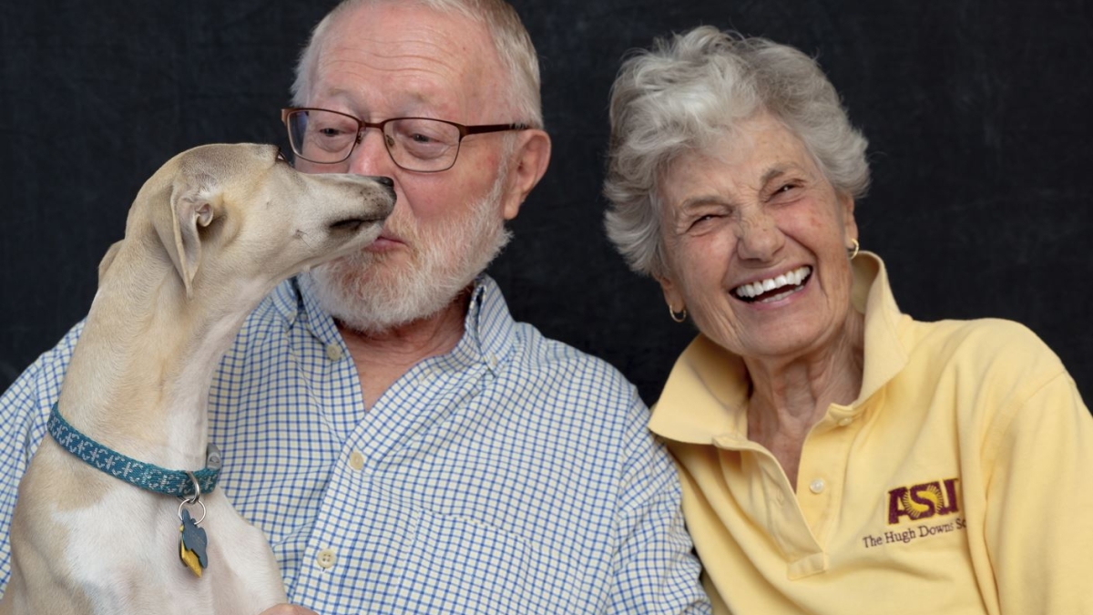 Late ASU Professor Emeritus Gene Valentine (left) smiling with his wife, Kristin, and their dog.